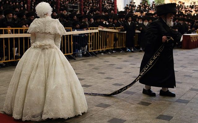 The bride,  Hana Batya Pener, is entreated to a "mitzvah tantz" at her wedding to Rabbi Shalom Rokach, the grandson of the Belz Rabbi, on Tuesday. The dance is a highlight of the wedding ceremony, in which the bride holds one end of a sash while her father and other important men in the community dance on the other end. (Photo credit: Yaakov Naumi/Flash90)